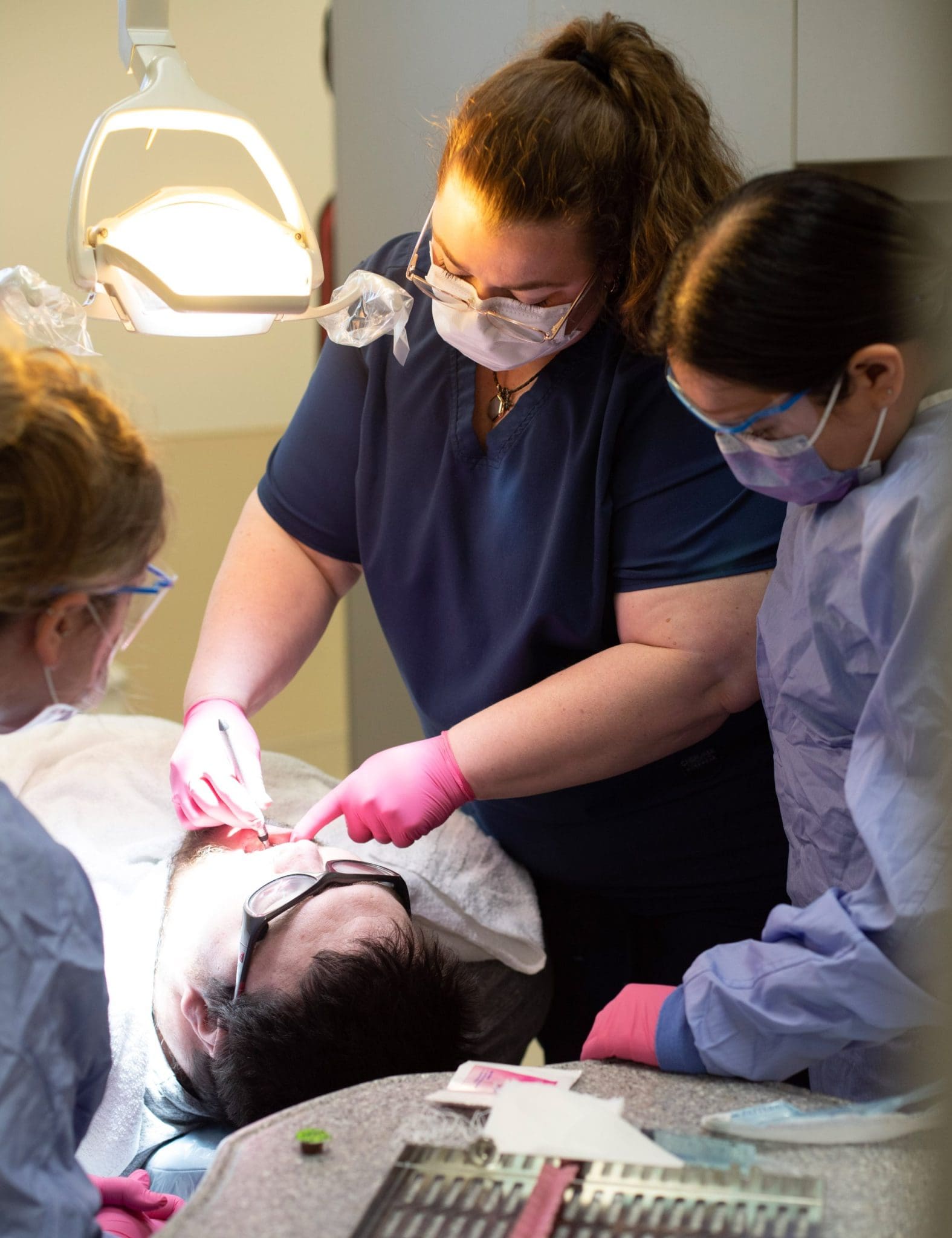 Dentist and dental students provide sensory-friendly care while treating an autistic patient during a specialized dental appointment.
